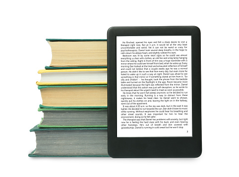 Portable e-book and stack of hardcover books on white background