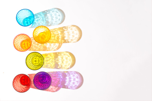 Six different colored glasses on white background. Flat lay image.