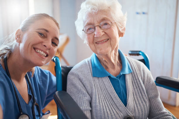 nurse, portrait smile and medical for elderly care, retirement home or visit from doctor for appointment or checkup. happy senior woman smiling with healthcare professional for therapy exam at clinic - ouderenzorg stockfoto's en -beelden
