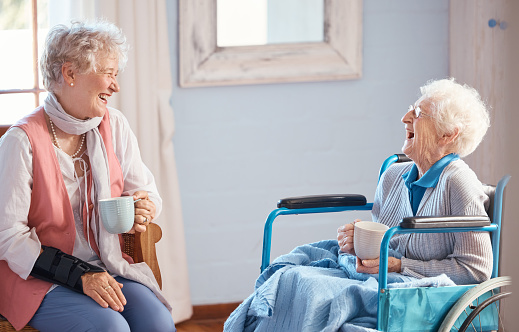 Medium shot of female friends having a good conversation while sitting on couch in living room during daytime