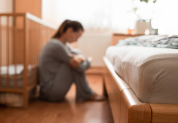 Madre stressata stanca a casa che si prende cura del bambino - foto stock