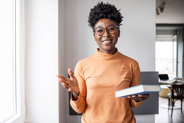 istock A young student holding a book and talking to camera 1468304688