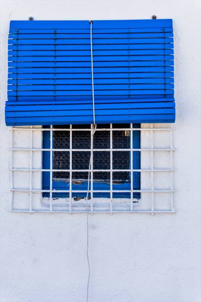 istock Modern Minimalist Home with White Facade and Striking Blue Window Grilles 1468305281