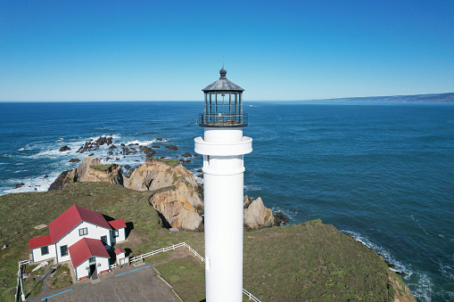 Point Arena Lighthouse drone aerial in northern California on sunny day. By Pacific Ocean. USA. Landmark