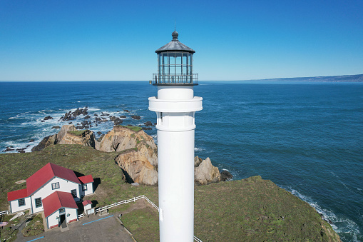 Point Arena Lighthouse drone aerial in northern California on sunny day. By Pacific Ocean. USA. Landmark