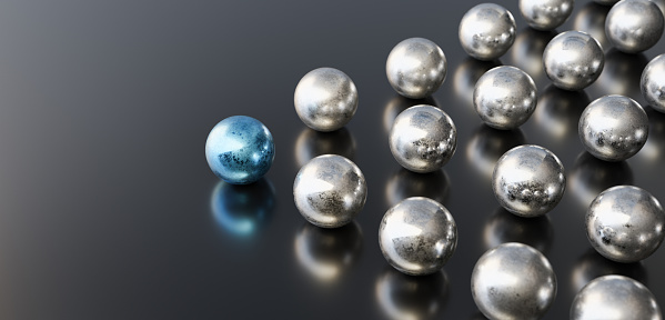 Leadership concept, blue leader ball leading silver balls, on black background with empty copy space on left side. 3D Rendering