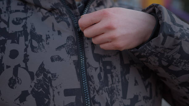 istock Young man closing his jacket zipper in close-up, cold weather concept 1468315715