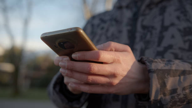istock Modern Communication at Your Fingertips: A Close-Up View of a Man's Hands Messaging on a Smartphone Outdoors 1468317134