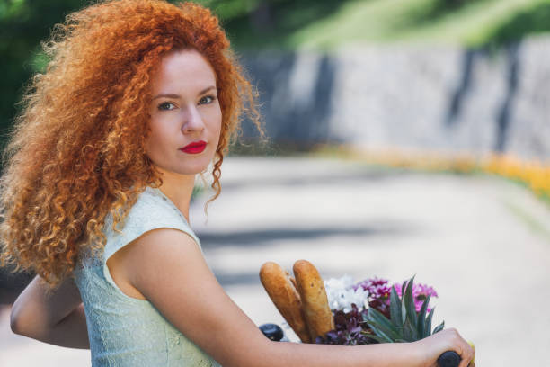 Shot of pretty young woman with a bike enjoying a springtime while going to market for grocery shopping