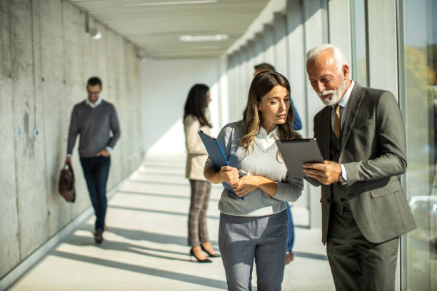 istock Group of business people walking through hallway and talking 1468320122