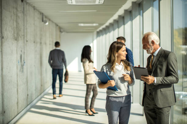 istock Group of business people walking through hallway and talking 1468320124