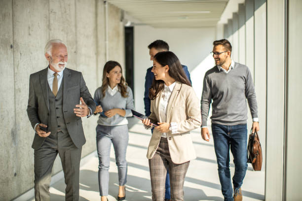 istock Group of business people walking through hallway and talking 1468320468