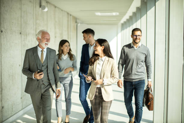 istock Group of business people walking through hallway and talking 1468320585