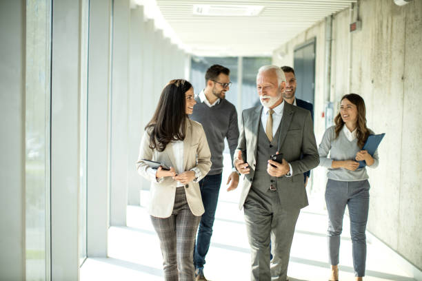 istock Group of business people walking through hallway and talking 1468320933