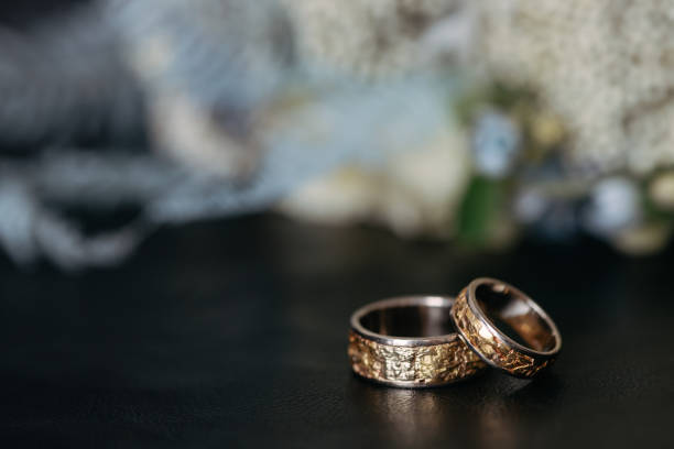 istock Two wedding gold rings lie one on top 1468321168