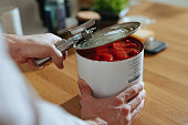 Close Up Photo Of Man’s Hands Opens Lid Of Canned Tomato Puree