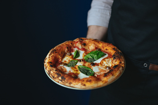 Ready To Eat: From above photo of an anonymous chef holding a freshly baked pizza.