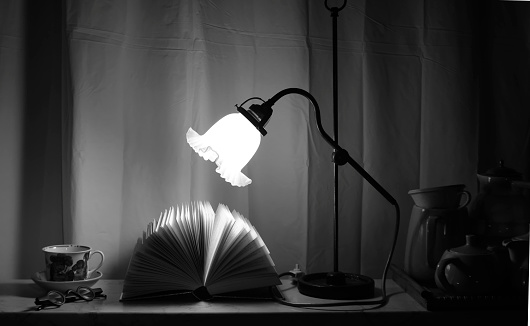 Open Book and a vintage lamp, glasses and tea cup,reading,education,learning concept, black and white, good copy space