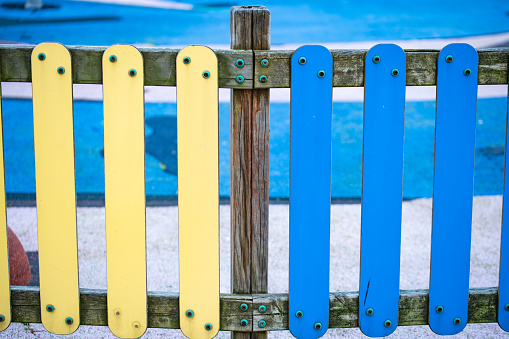 Yellow and blue wooden fences of a playground