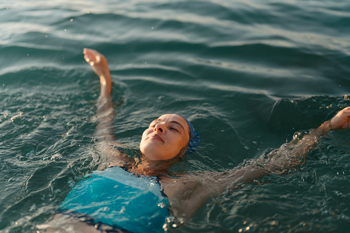 Photo of a mid-adult woman who is having daily swim training in the sea