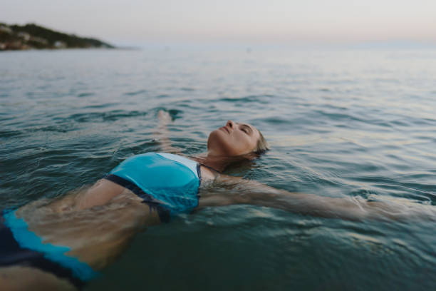 взрослая женщина, плавающая в море - sea swimming greece women стоковые фото и изображения