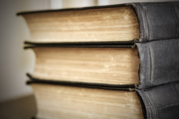 istock Old books are stacked close-up, binding black covers, selective focus, side view 1468337528