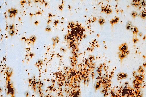 horizontal front view closeup of square empty rusted metal signboard plate with weathered texture isolated on white background