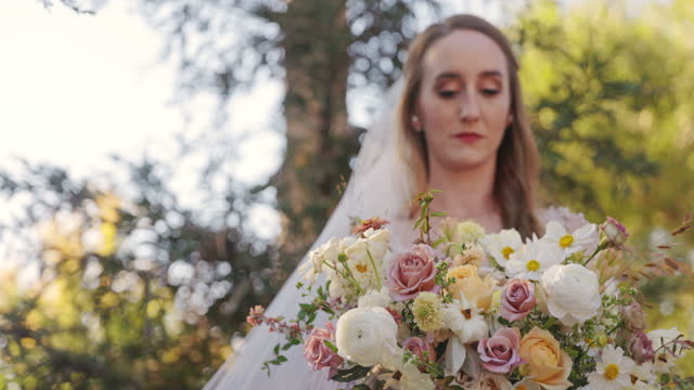 Beautiful Bride on her wedding day in nature with wedding dress and flowers