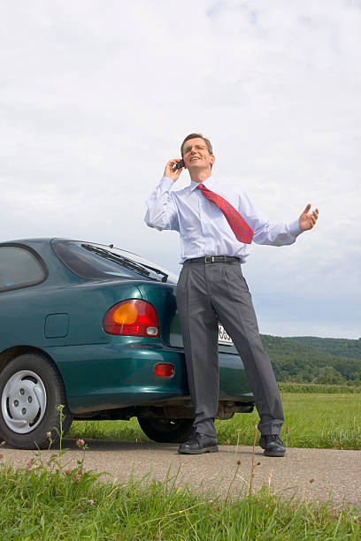 istock Businessman talking on cell phone beside his car 146834628