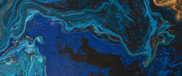 istock Fluorescent fluid art background in blue tints with gilding. Flowing wave effect of liquid ink. Dark phantom blue with golden dust. Abstract texture of acrylic paints. Surreal color mix. Gold on blue. 1468347072