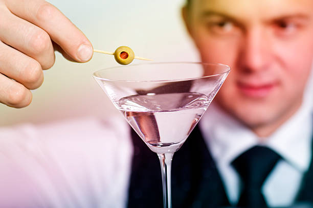 istock Barman removes olive garnish from martini 146834770