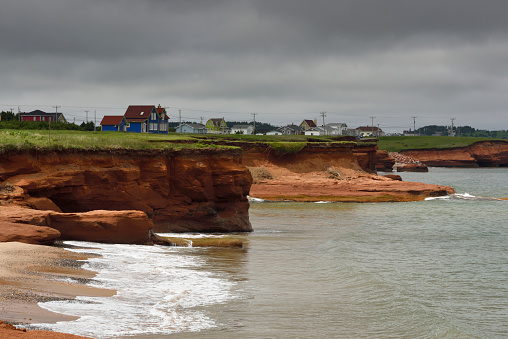Eroded red cliff and beach of coastal village of Cap-aux-meules, Magdalen Islands, Quebec