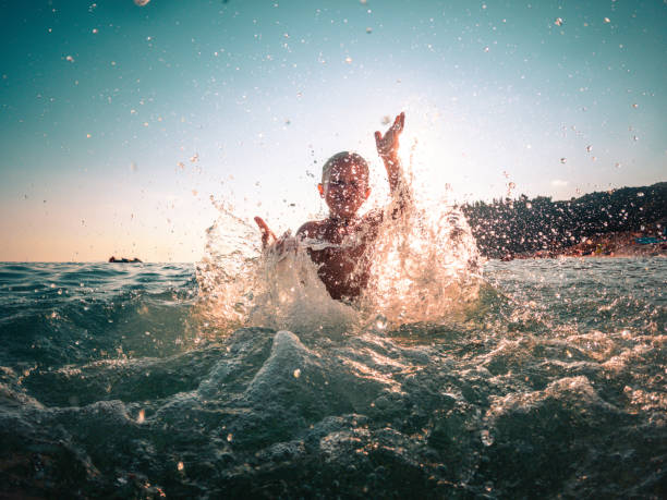 istock Playful Kid with Hands Up inside the Sea Splattering 1468348230