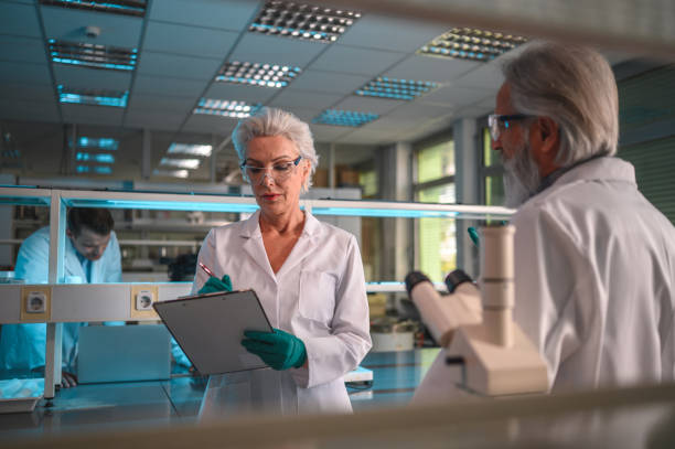 istock Female Scientist Controlling Notes With a Male Colleague 1468349574