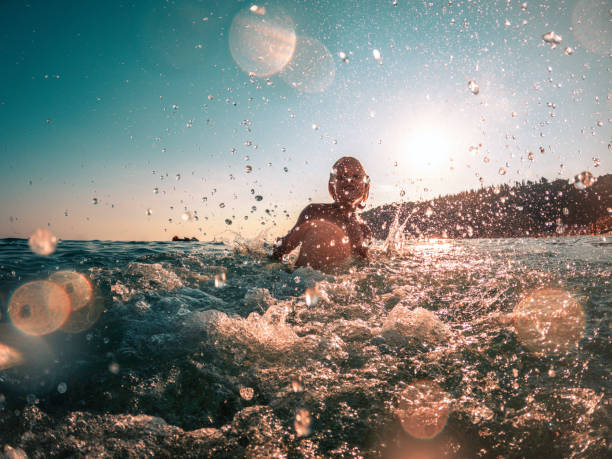 istock Cheerful Boy Playing Inside the Water While on Short Summer Trip 1468349598