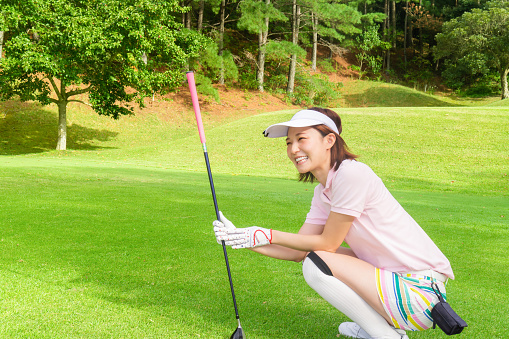 Beautiful young asian woman play golf