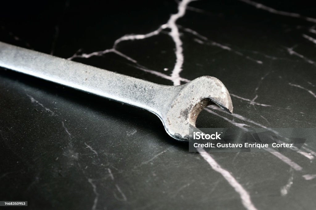 old spanner for nuts old rusty fixed wrench for nuts on a dark marble background Adjustable Stock Photo