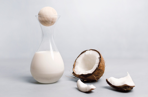 Coconut milk in a bottle with fresh coconut