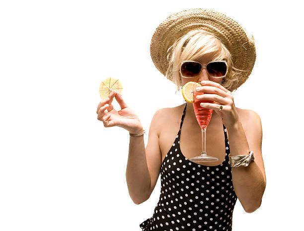 blonde girl in straw hat enjoys a cocktail stock photo