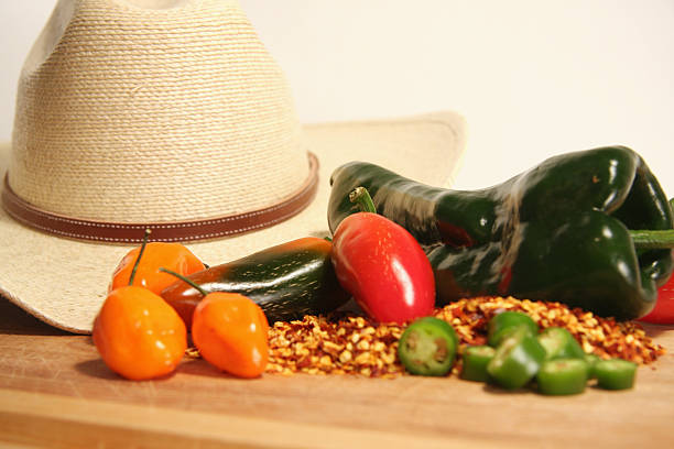 Cowboy hat and Hot Peppers Southwest, spicy peppers with a backgound of a cowboy hat anaheim pepper photos stock pictures, royalty-free photos & images