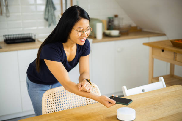 istock Happy Asian woman using a mobile app for setting up smart home system 1468358342