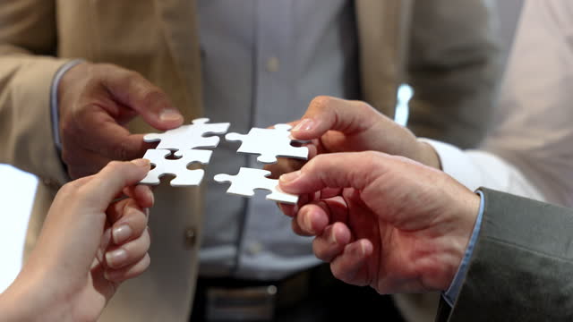 Group of business people holding a jigsaw puzzle pieces.