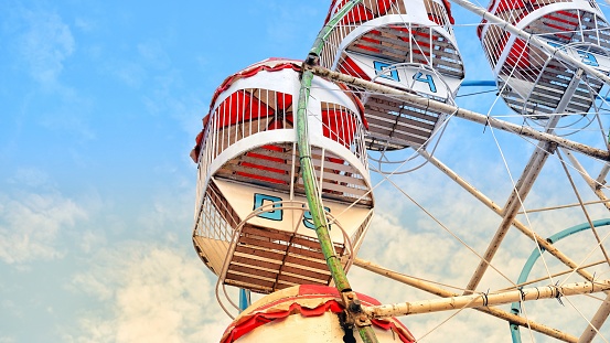 ferris wheel without people in the amusement park against blue sky background . Holidays and summer festival concept