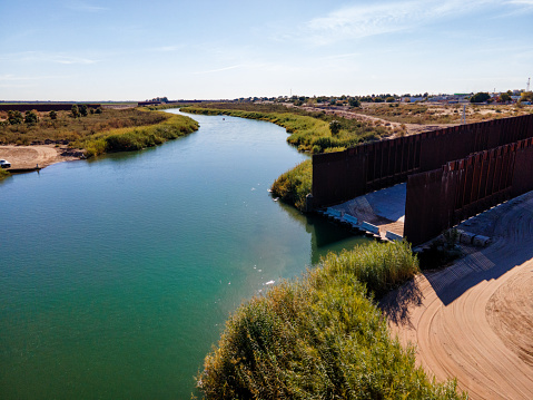 Border Wall, Colorado Diversion Dam River Drainage at Barrier Between Yuma Arizona and Algodones, Baja California Norte Mexico on a Sunny Day