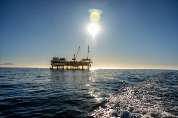 große erdöl-gas- und öl-offshore-bohrinsel in ruhigem wasser an einem klaren abend in der abenddämmerung mit catalina island im fernen hintergrund - oil rig sea oil storm stock-fotos und bilder