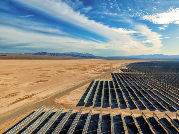 istock Solar Panel Array Farm in Desert Area South of Boulder City Nevada on a Sunny Day with Sloan Canyon National Conservation Area and North McCullough Mountains in the Distance, Drone Flying Low Solar Farm 1468371782