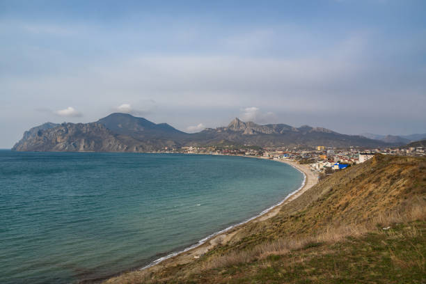 View of seaside resort city Koktebel , mountain Kara Dag from hill in spring. Crimea View of seaside resort city Koktebel , mountain Kara Dag from hills in spring. Crimea feodosiya stock pictures, royalty-free photos & images