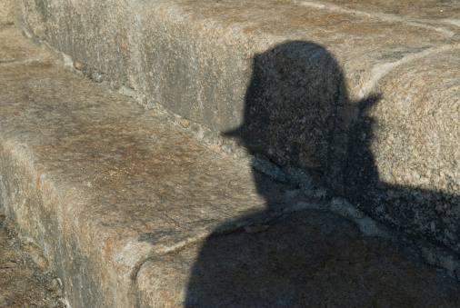A shadow of a person wearing a hat
