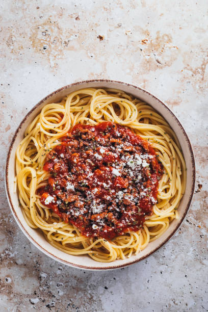 Flat lay view of spaghetti with bolognese sauce on stone background.