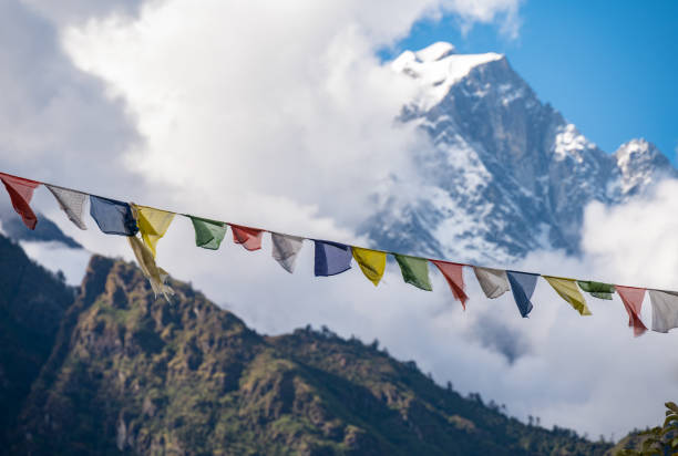 banderas de oración ondeando en el viento con la montaña nevada en el fondo. - tibetan buddhism wind tibet horizontal fotografías e imágenes de stock